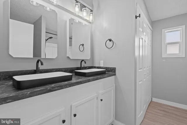 a bathroom with double sink and a mirror