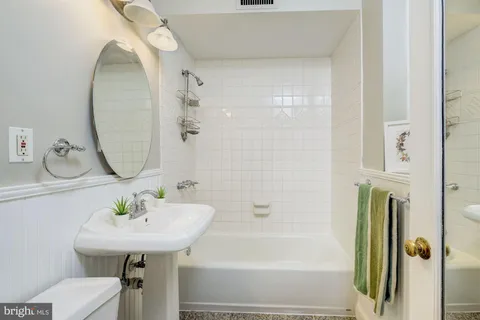 a bathroom with a sink toilet and a mirror