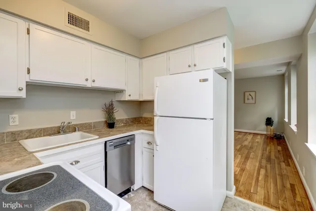 a kitchen with a white stove refrigerator and a sink with granite countertops