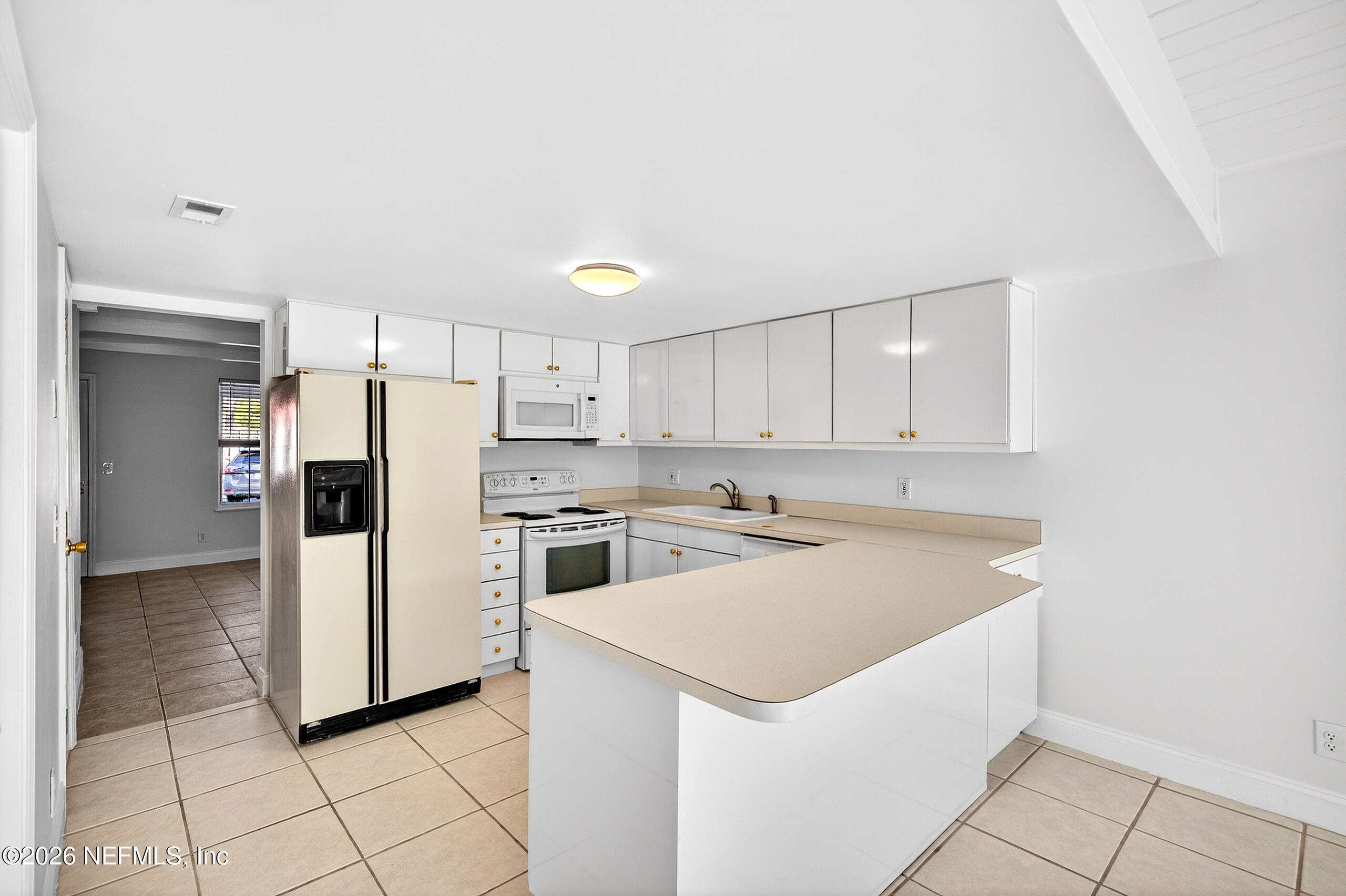 4358 Timuquana Road, Unit 150 Jacksonville, FL 32210 - Photo 4 of 21 a kitchen with white cabinets and white appliances