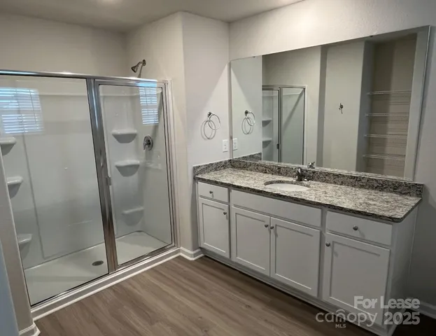 a spacious bathroom with a granite countertop sink mirror and shower