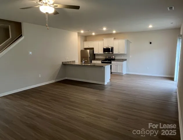 a view of kitchen with refrigerator microwave and cabinets