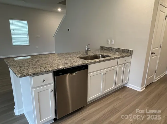 a kitchen with sink cabinets and wooden floor