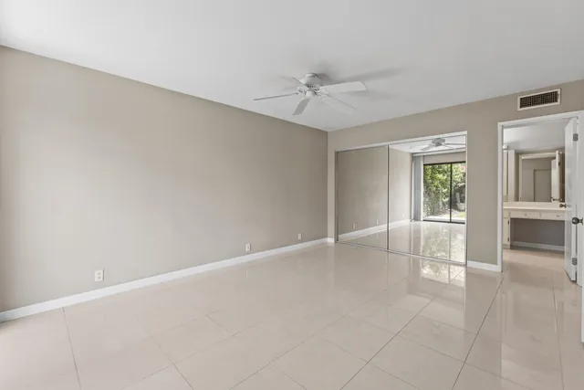 an empty room with windows and fan