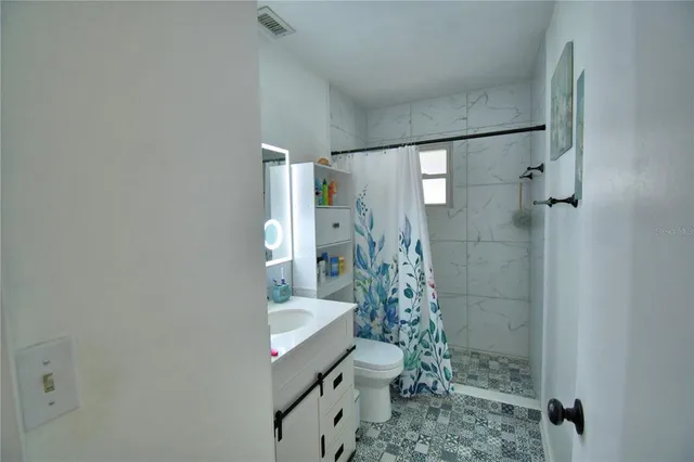 a bathroom with a sink toilet and shower