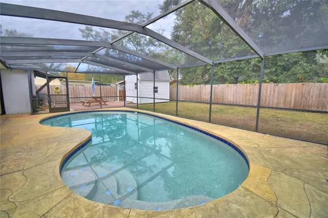 a view of a backyard with a patio and wooden fence
