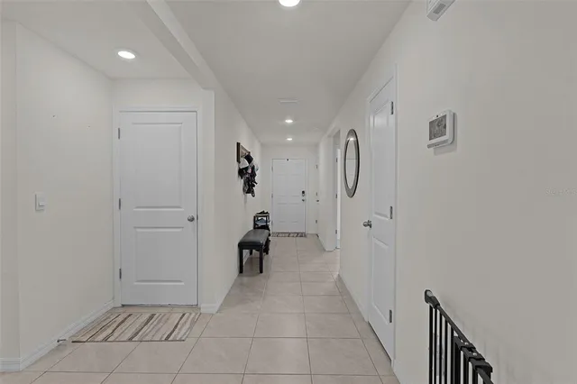 a view of a hallway with wooden floor and a bathroom
