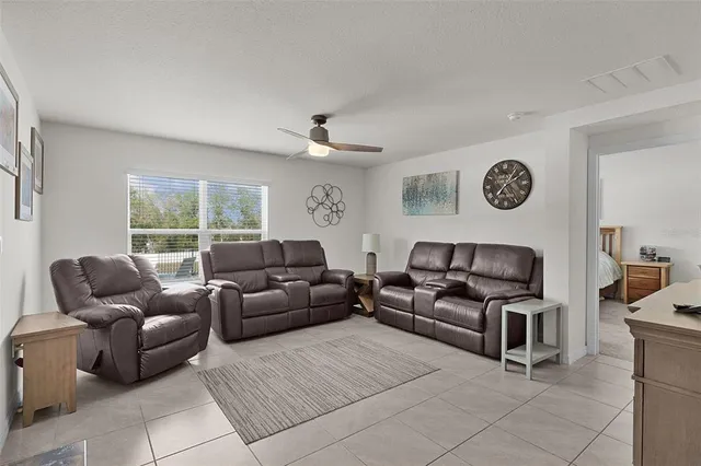 a living room with furniture a clock and a window