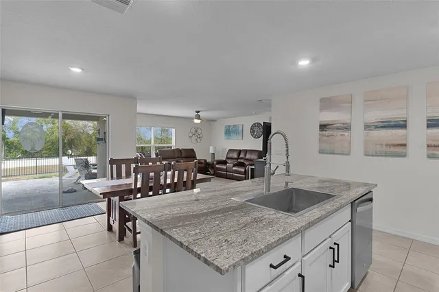 a kitchen with granite countertop a sink a counter top space and living room