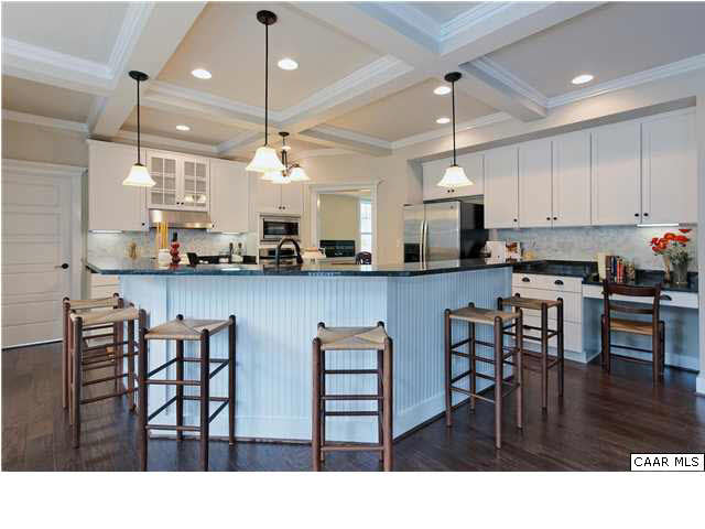 5309 Raven Stone Road Crozet, VA 22932 - Photo 11 of 38 a kitchen with stainless steel appliances kitchen island granite countertop a dining table chairs and white cabinets