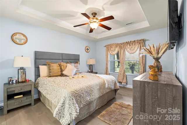 a bedroom with a bed and a flat tv screen on dresser