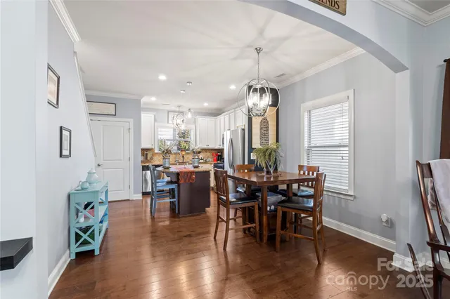 a view of a dining room with furniture wooden floor and chandelier