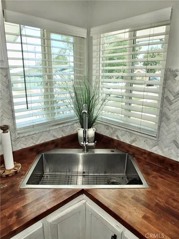 a view of a kitchen counter top a sink and cabinets