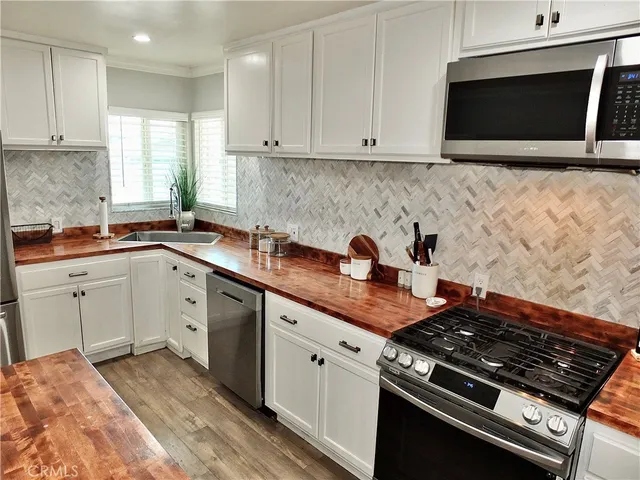 a kitchen with stainless steel appliances granite countertop a sink stove and microwave