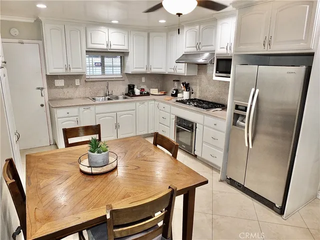 a kitchen with stainless steel appliances a stove a sink cabinets and a refrigerator