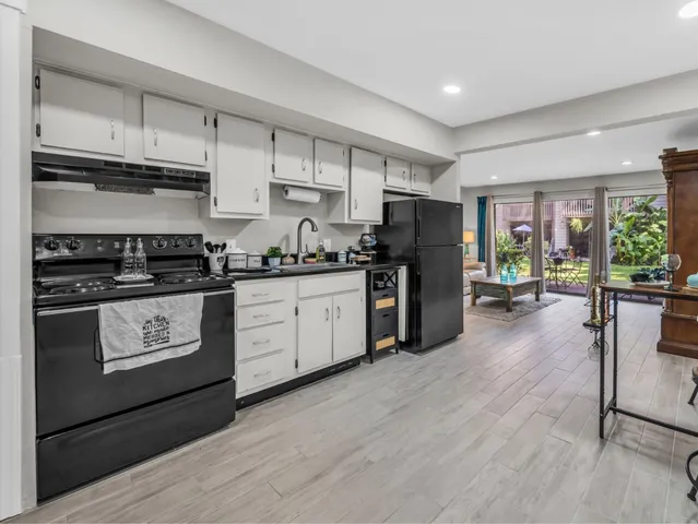 a kitchen with stainless steel appliances a refrigerator a stove a sink dishwasher and a refrigerator with wooden floor