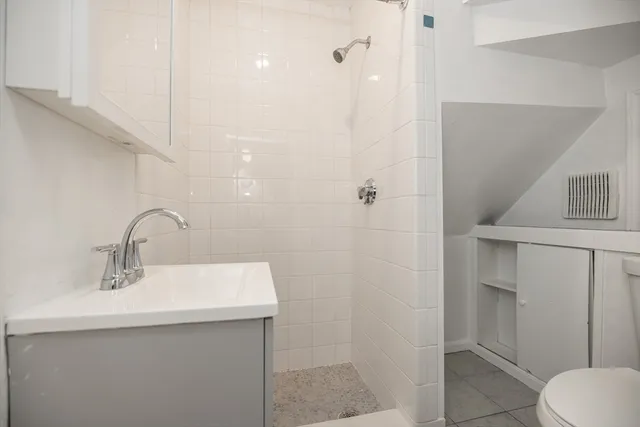 a bathroom with a sink a toilet and shower