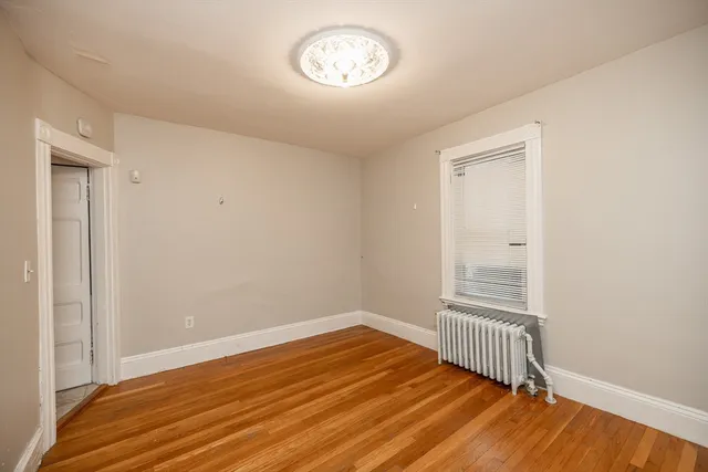 a view of a room with wooden floor and a window