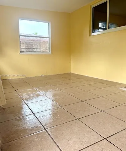a view of a livingroom with an empty space and a window
