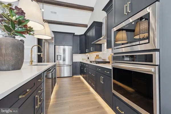 a kitchen with stainless steel appliances kitchen island granite countertop a stove a sink and a microwave