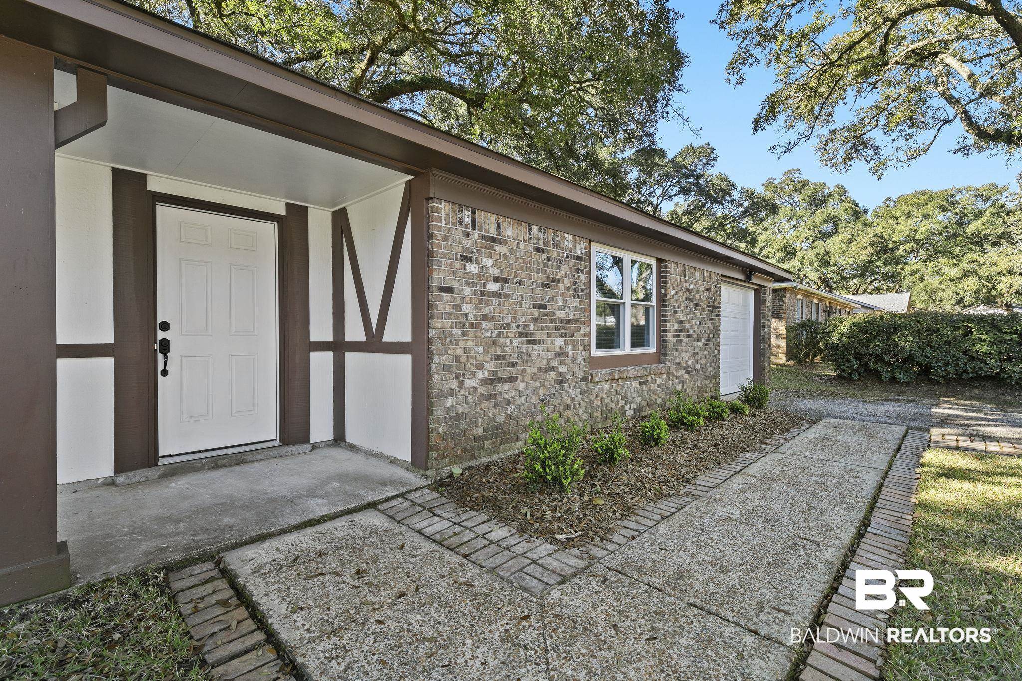 5817 Woodgate Road Mobile, AL 36609 - Photo 8 of 85 Entrance to property featuring brick siding and an attached garage