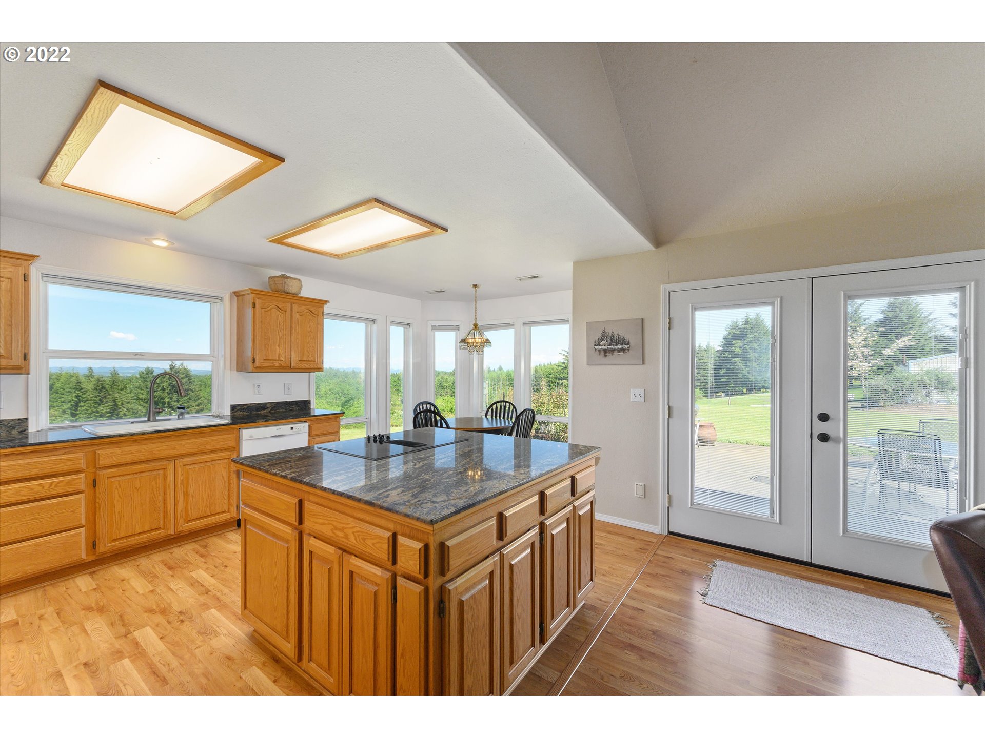 16750 Oakdale Road Dallas, OR 97338 - Photo 7 of 32 a dining hall with stainless steel appliances granite countertop a refrigerator a sink dishwasher and wooden cabinets with a large window