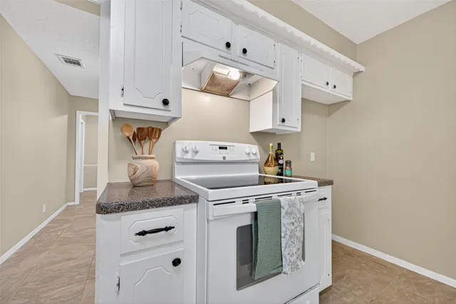 a kitchen with white cabinets and white appliances