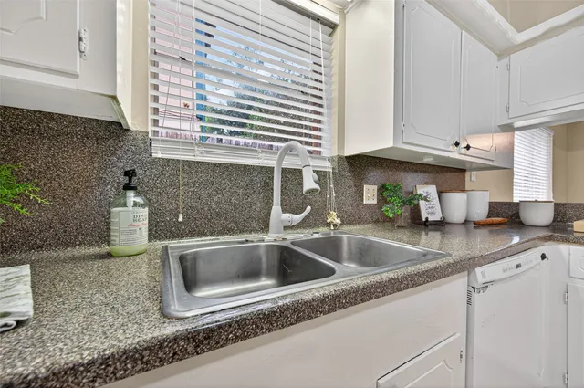 a kitchen with granite countertop a sink and a stove next to a window