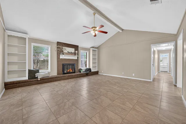 wooden floor fireplace and windows in an empty room