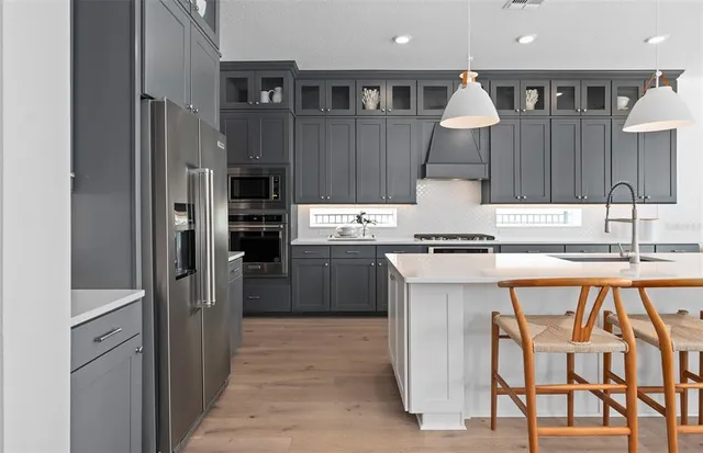 a kitchen with stainless steel appliances kitchen island granite countertop a stove a sink and a cabinets