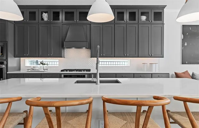 a kitchen with a sink a counter space appliances and cabinets