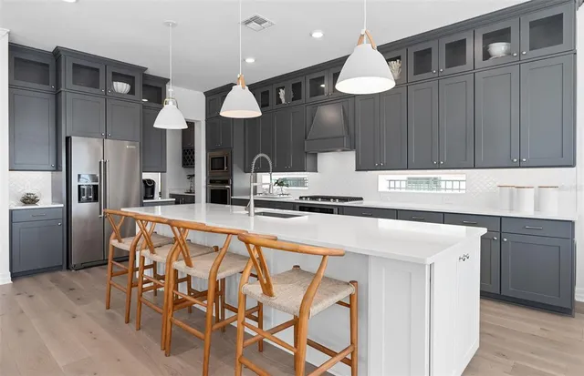 a kitchen with stainless steel appliances a stove a sink dishwasher and cabinets with wooden floor