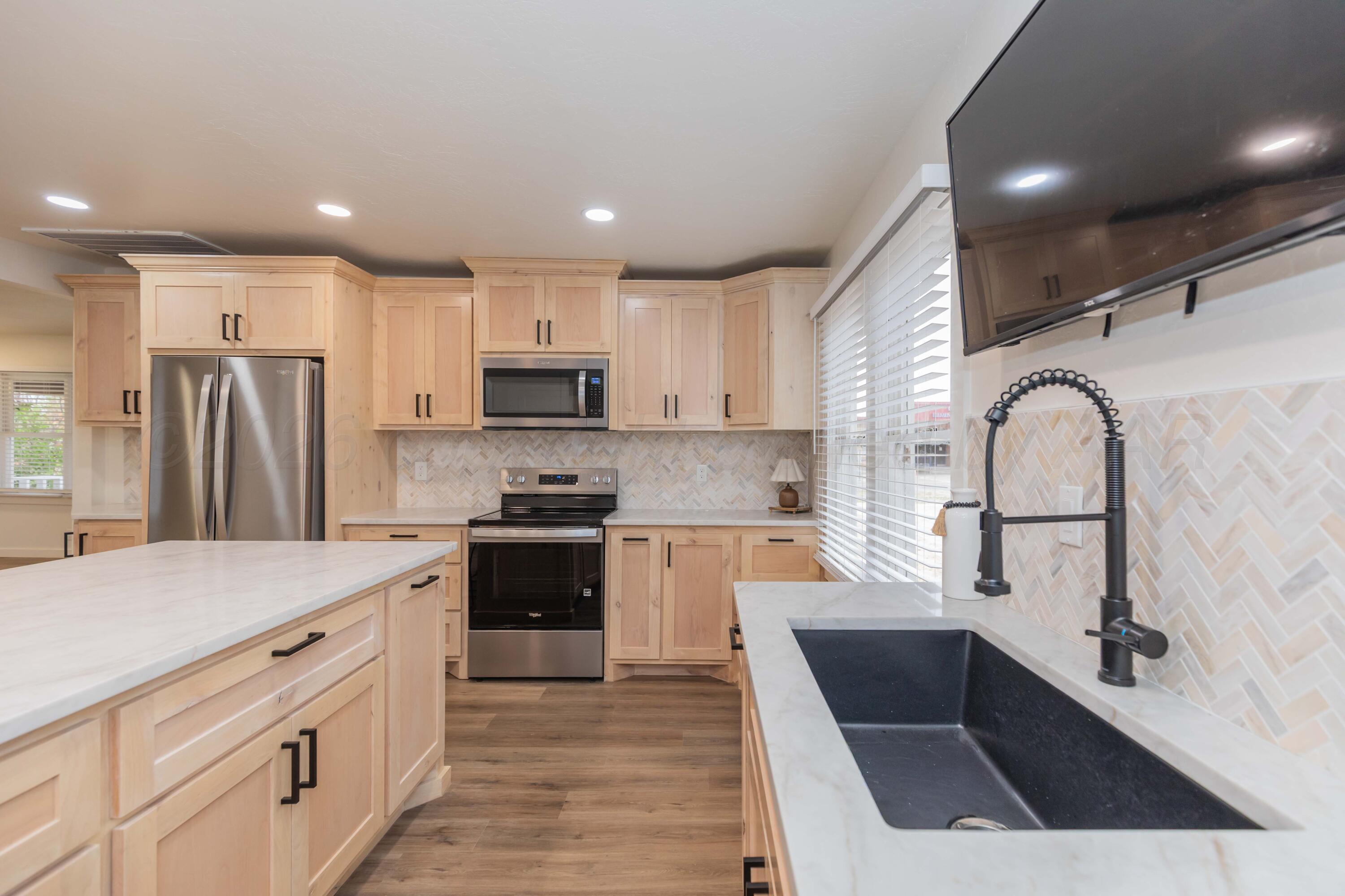 504 High Street Claude, TX 79019 - Photo 21 of 39 a kitchen with white cabinets and stainless steel appliances