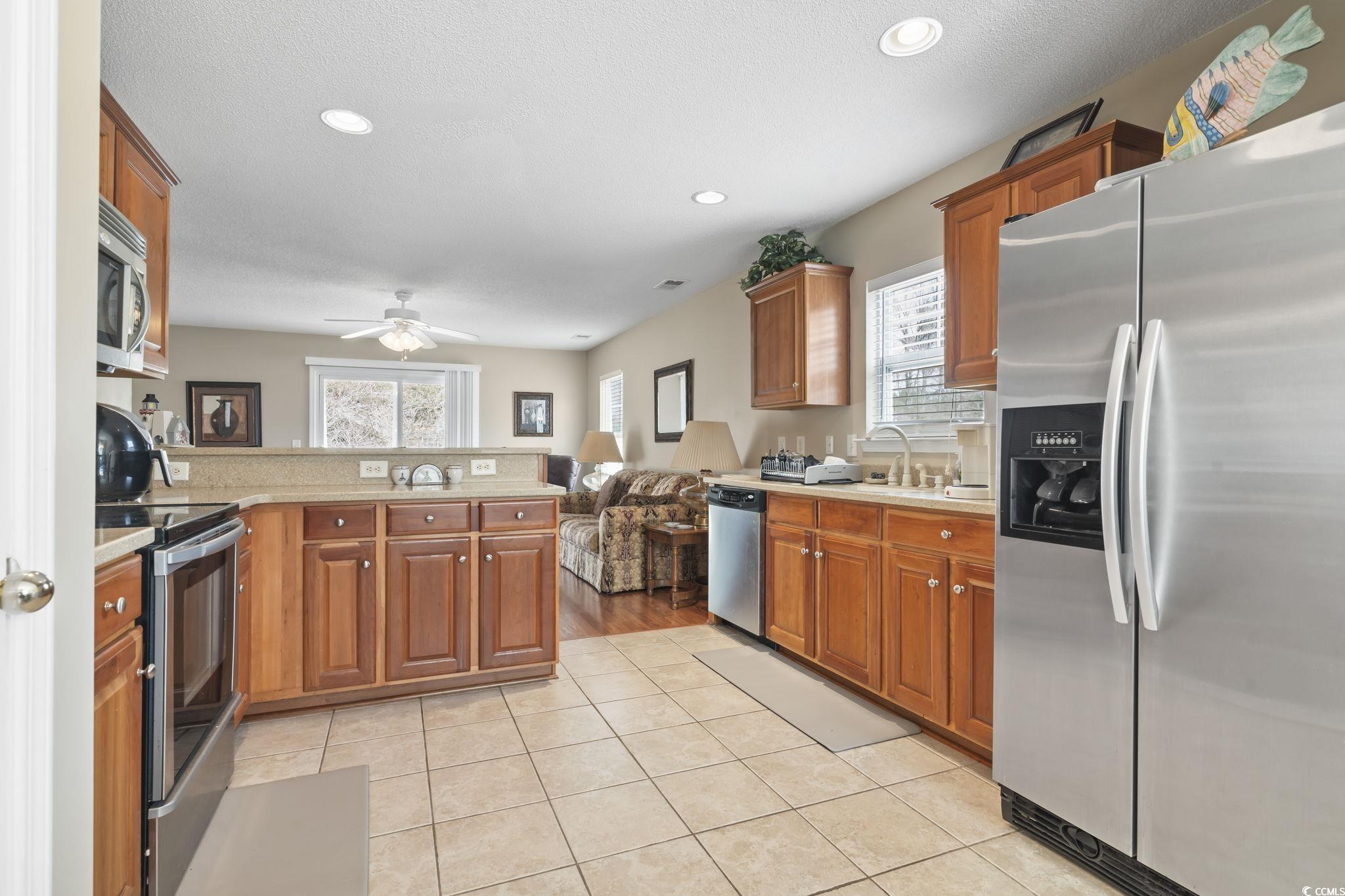 2288 Beauclair Court Myrtle Beach, SC 29579 - Photo 10 of 40 Kitchen featuring appliances with stainless steel finishes, light countertops, a peninsula, and light tile patterned flooring