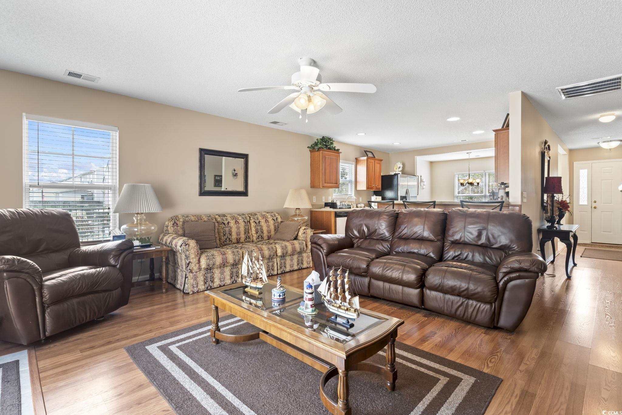 2288 Beauclair Court Myrtle Beach, SC 29579 - Photo 14 of 40 Living area featuring a textured ceiling, ceiling fan, light wood-type flooring, and visible vents