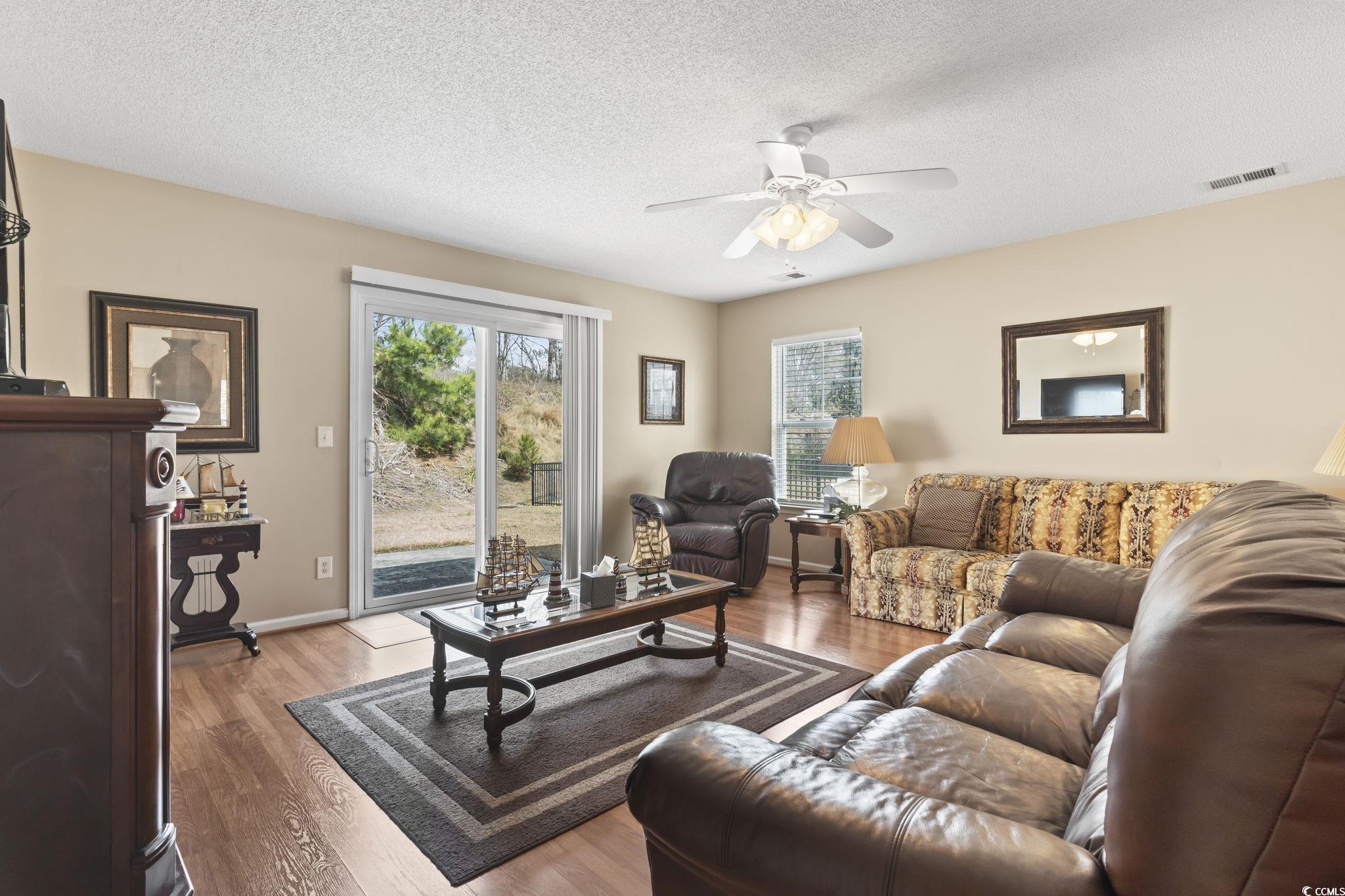 2288 Beauclair Court Myrtle Beach, SC 29579 - Photo 16 of 40 Living area with ceiling fan, a textured ceiling, visible vents, and wood finished floors