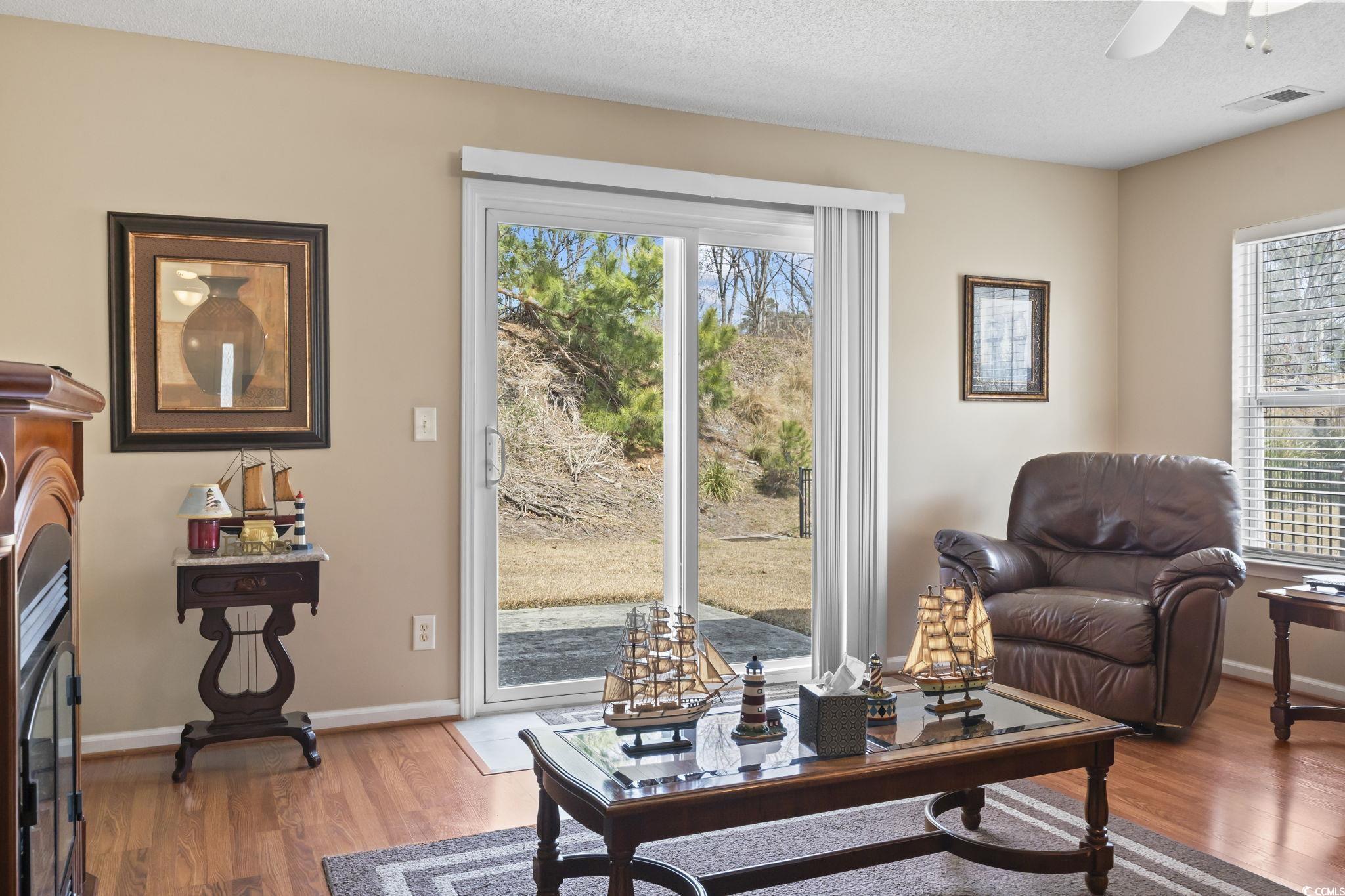 2288 Beauclair Court Myrtle Beach, SC 29579 - Photo 17 of 40 Living area featuring a textured ceiling, a fireplace, wood finished floors, and visible vents