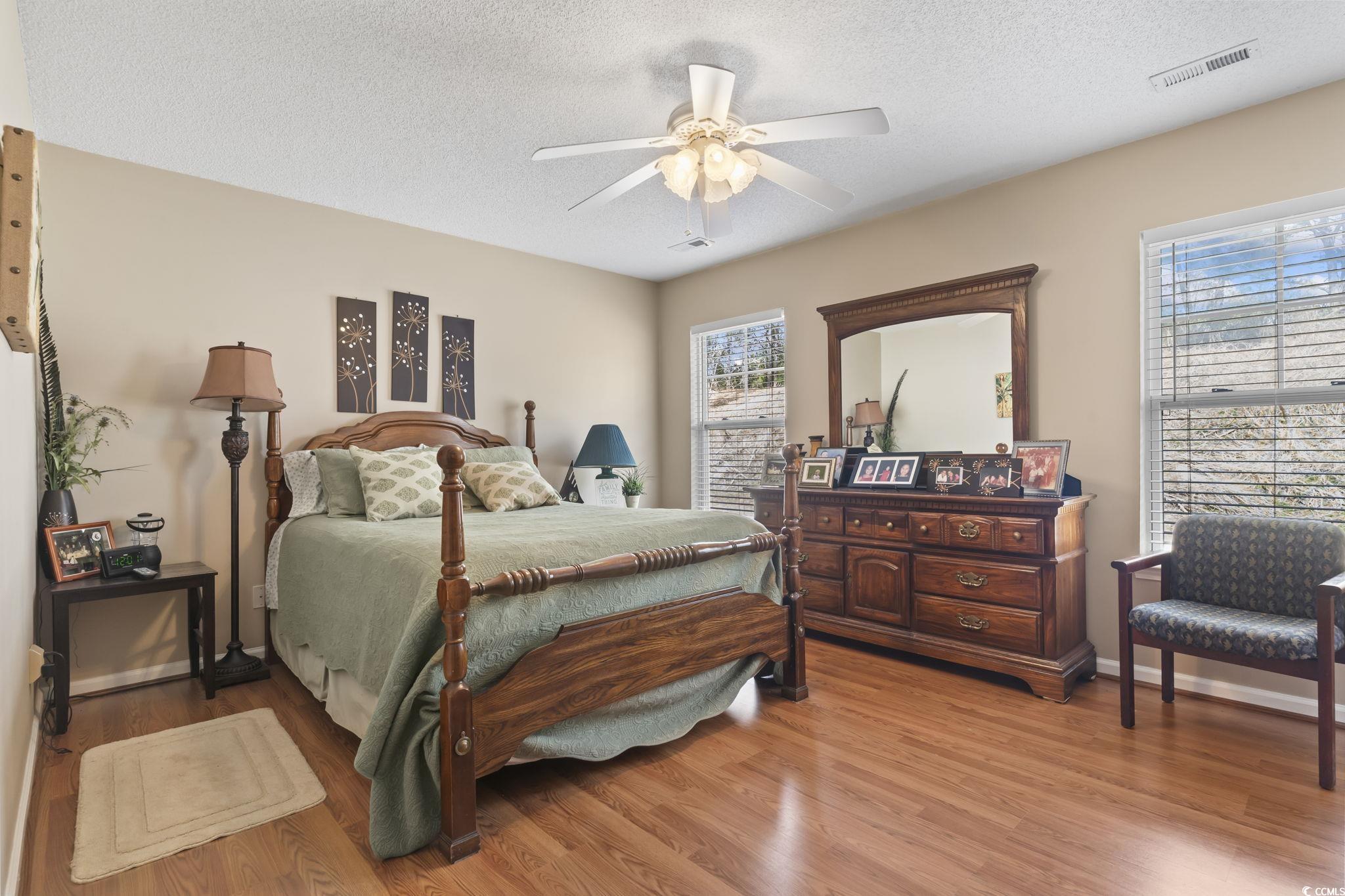 2288 Beauclair Court Myrtle Beach, SC 29579 - Photo 18 of 40 Bedroom featuring multiple windows, visible vents, a textured ceiling, and wood finished floors