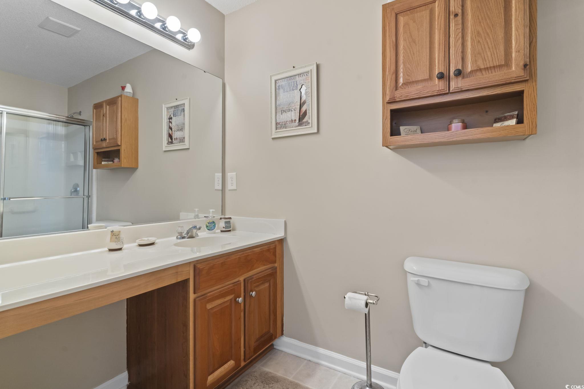 2288 Beauclair Court Myrtle Beach, SC 29579 - Photo 21 of 40 Bathroom with toilet, vanity, baseboards, tile patterned floors, and an enclosed shower