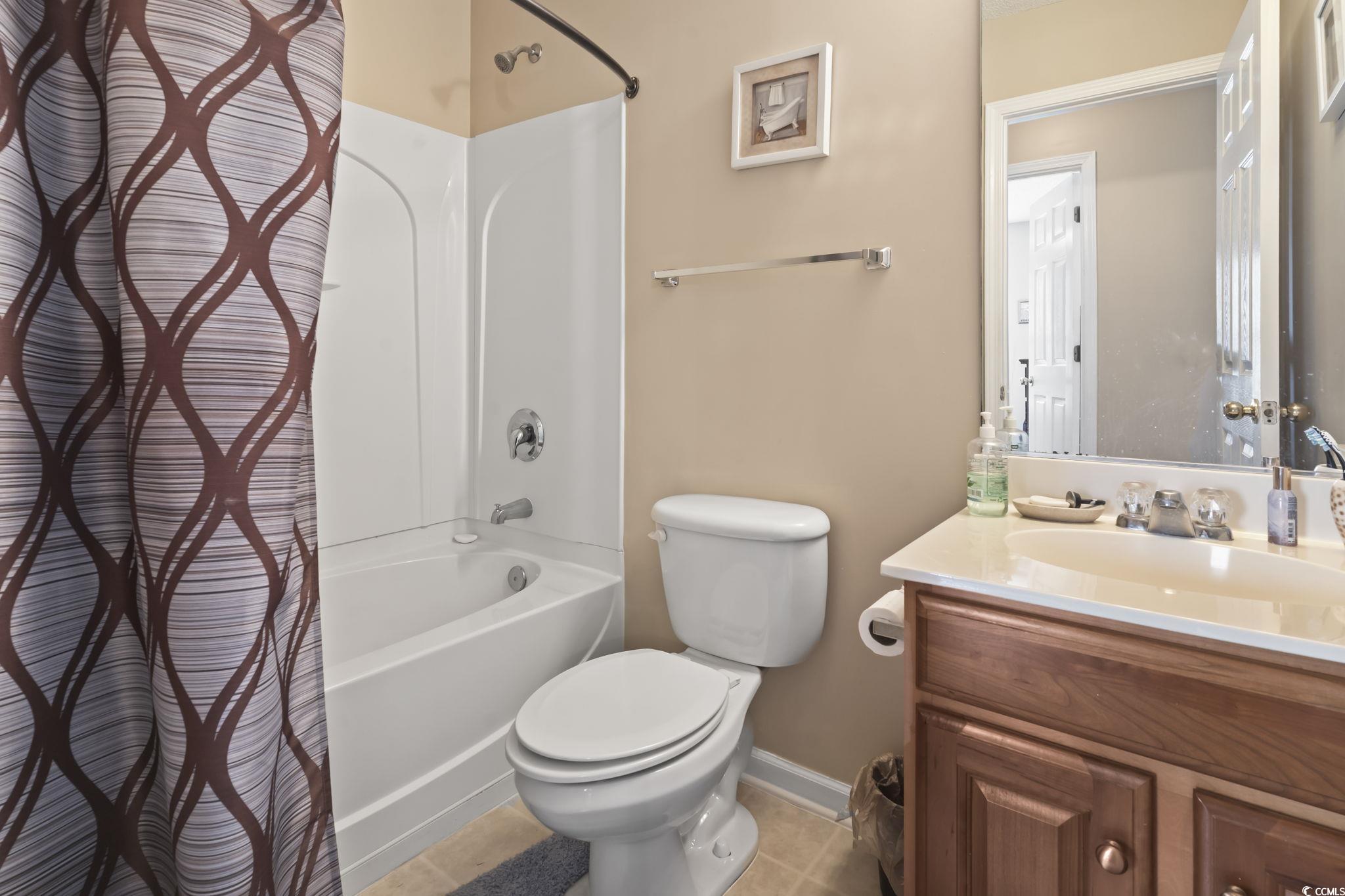 2288 Beauclair Court Myrtle Beach, SC 29579 - Photo 24 of 40 Full bath featuring tile patterned flooring, toilet, vanity, baseboards, and shower / bathtub combination with curtain