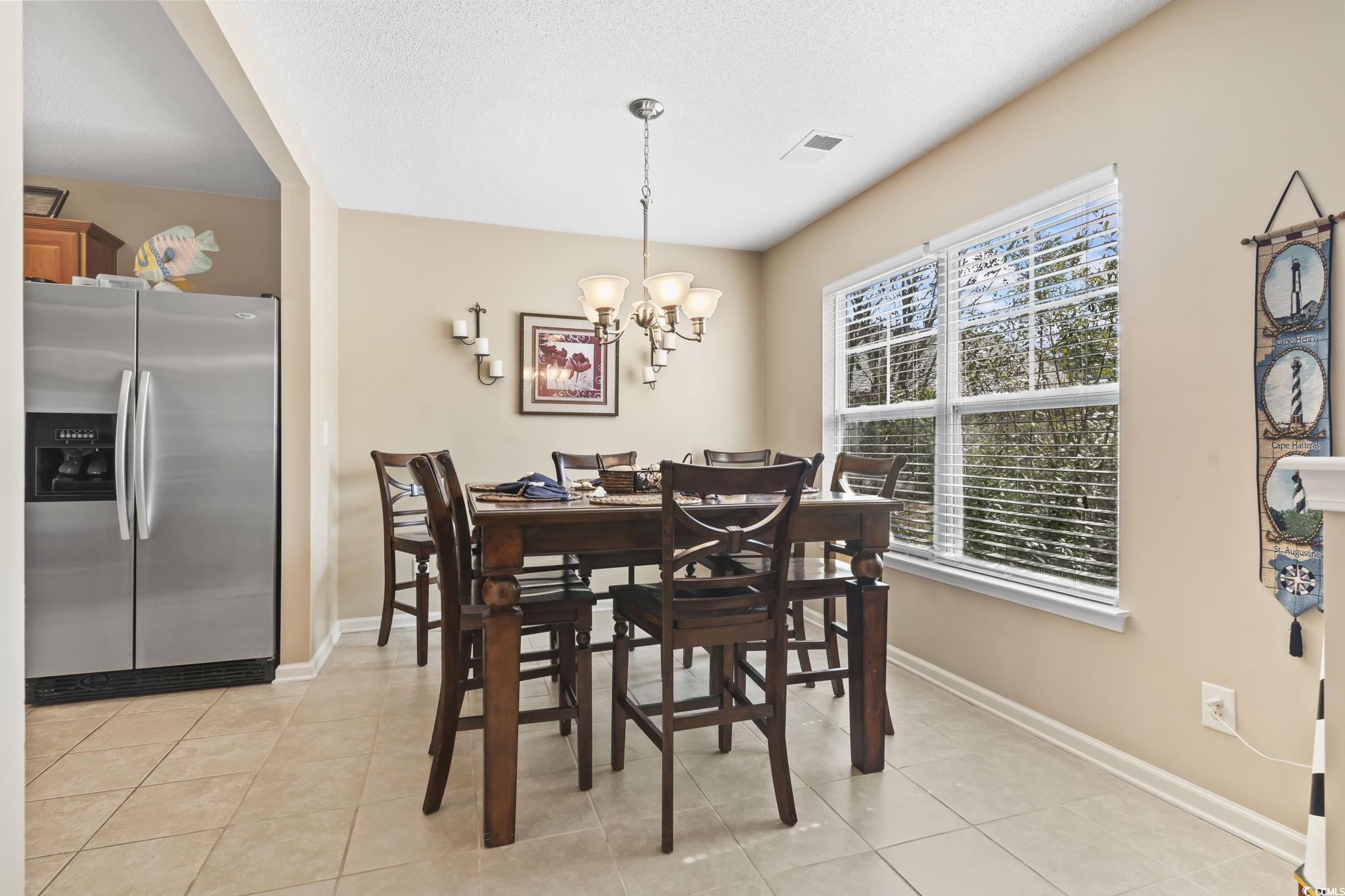 2288 Beauclair Court Myrtle Beach, SC 29579 - Photo 7 of 40 Dining space featuring a chandelier, light tile patterned floors, and baseboards