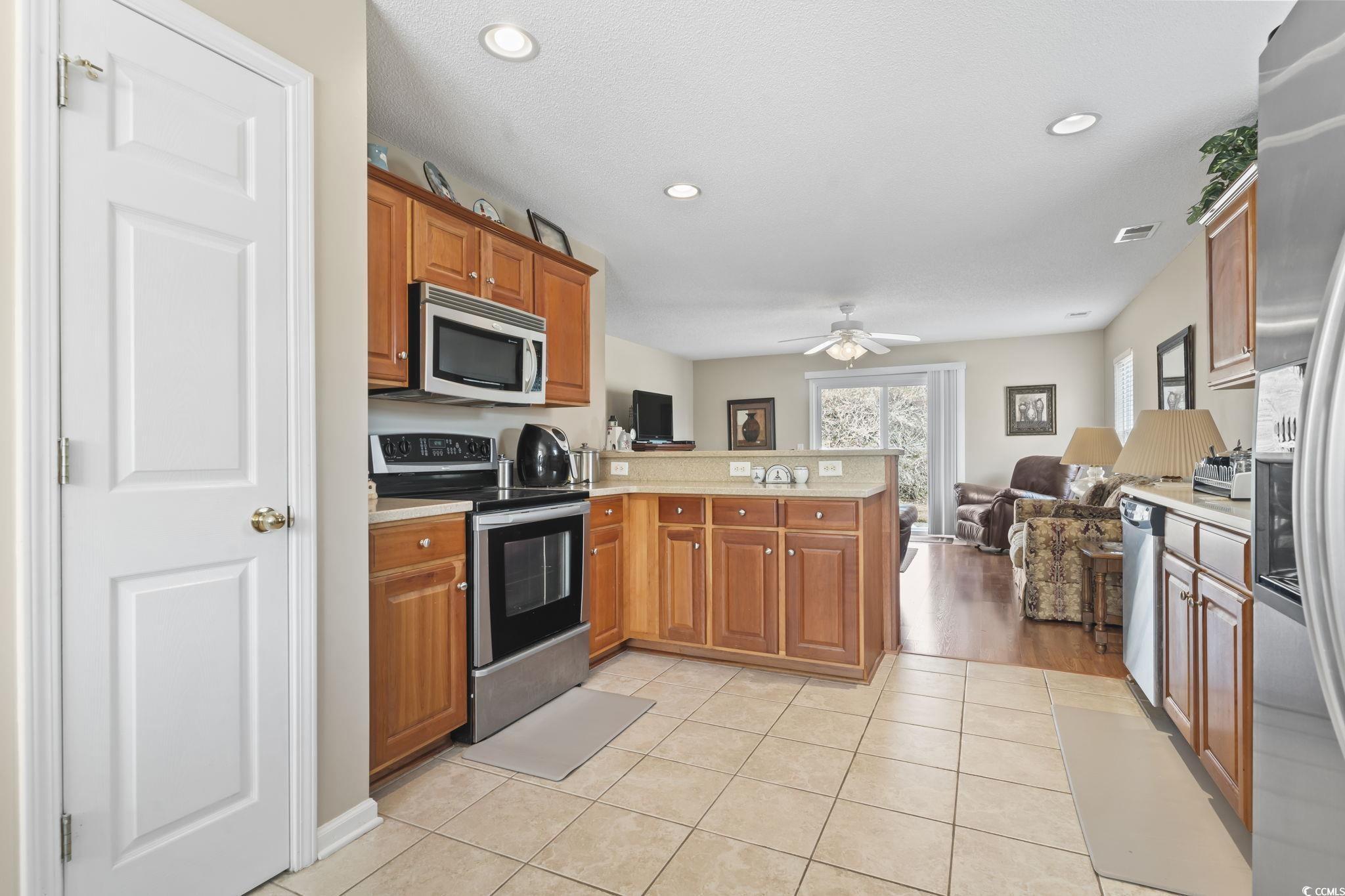 2288 Beauclair Court Myrtle Beach, SC 29579 - Photo 40 of 40 Kitchen with light tile patterned floors, light countertops, appliances with stainless steel finishes, open floor plan, and a peninsula