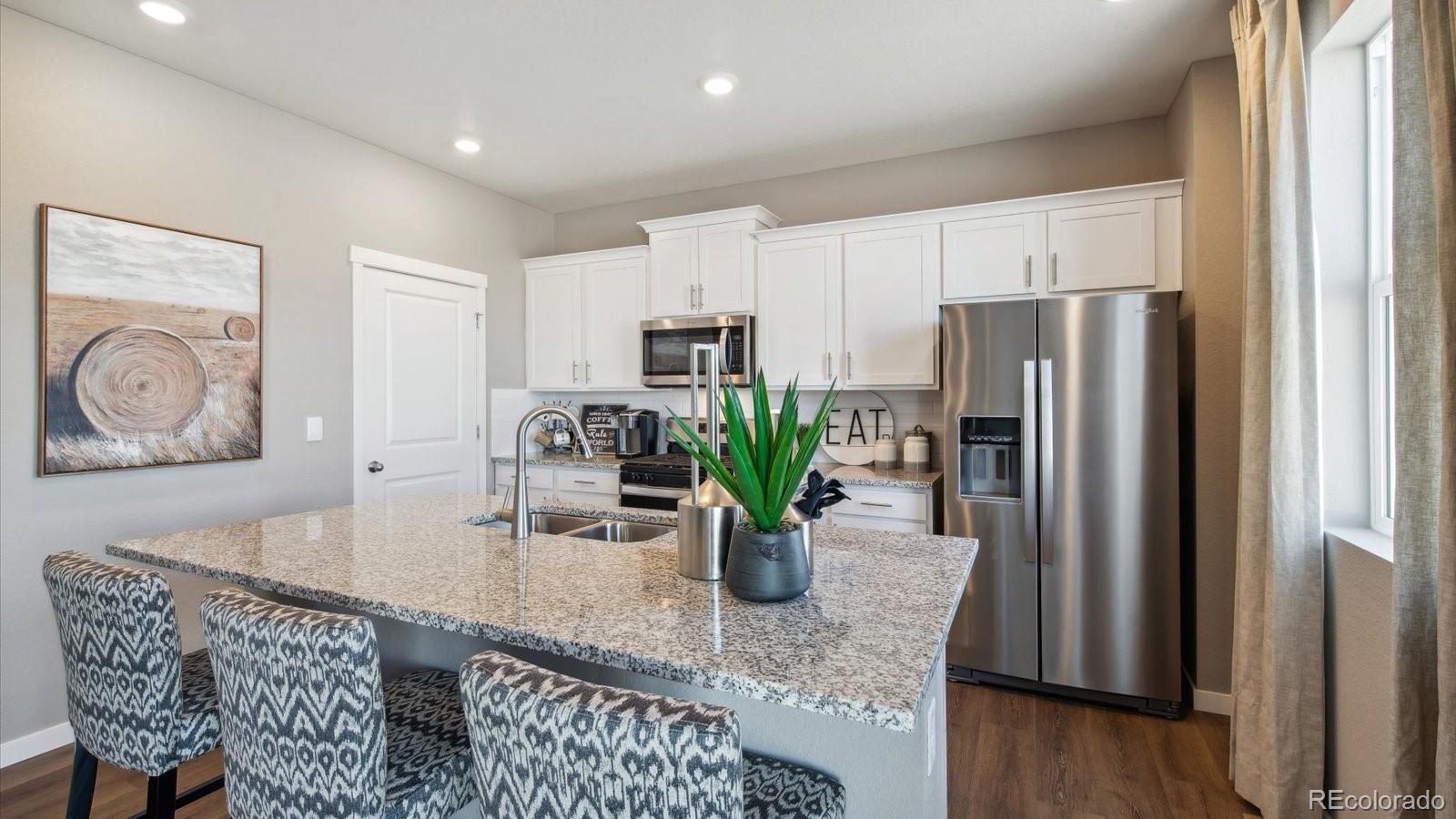 2202 Base Street Fort Lupton, CO 80621 - Photo 11 of 24 a kitchen with dining table a refrigerator and a window