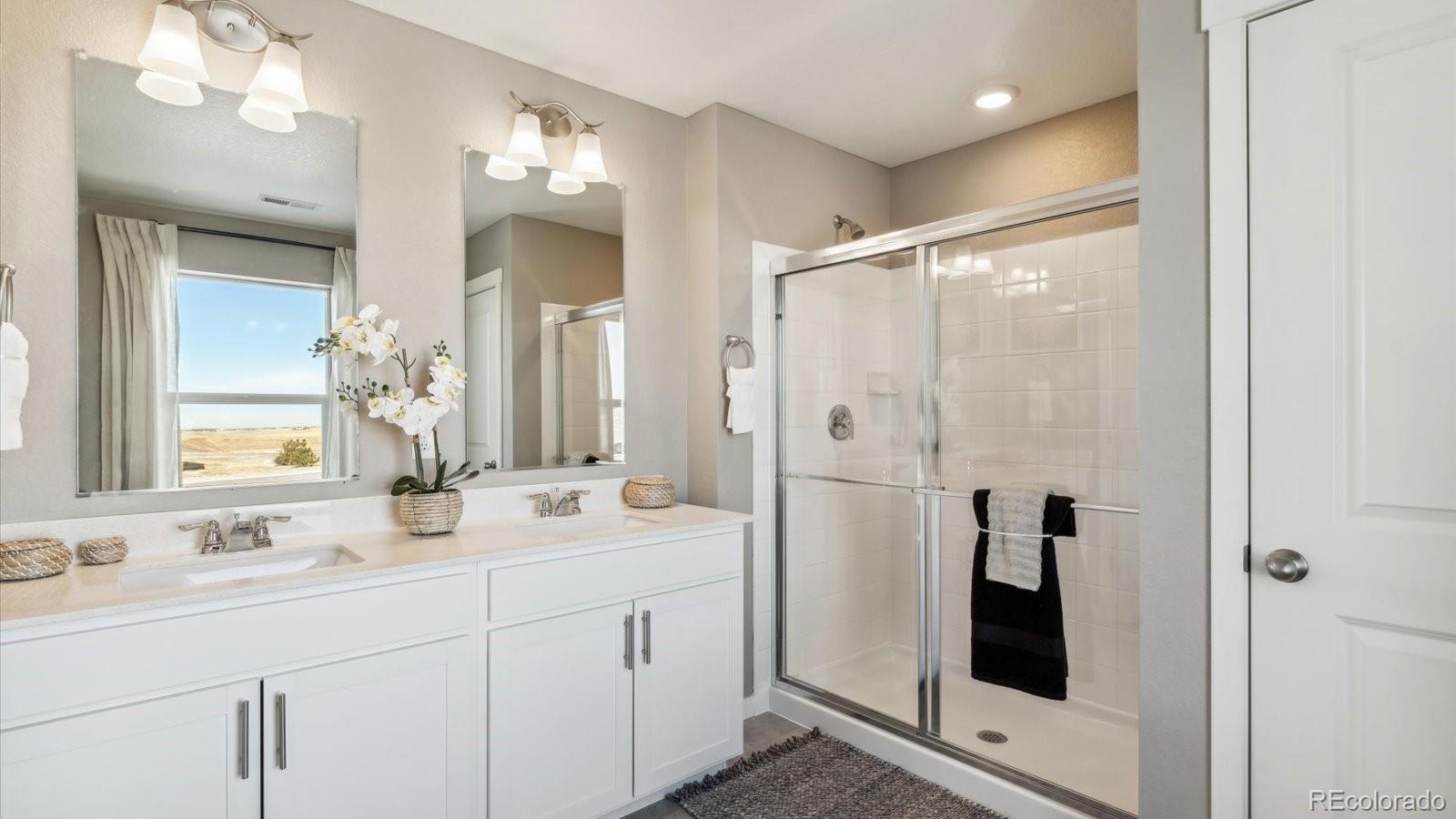 2202 Base Street Fort Lupton, CO 80621 - Photo 20 of 24 a bathroom with a double vanity sink mirror and shower