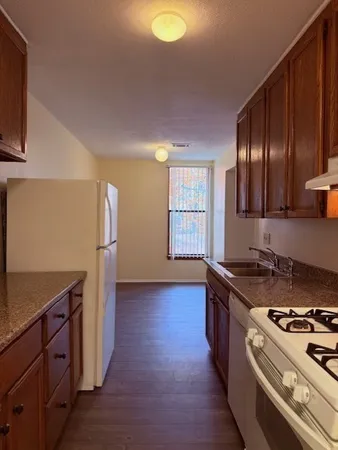 a kitchen with granite countertop a stove and a refrigerator