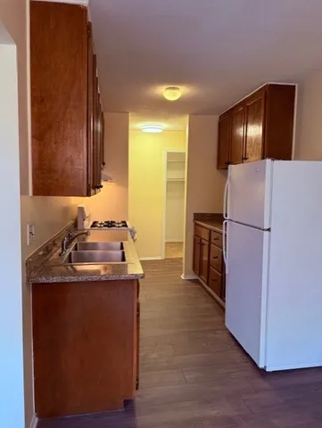 a kitchen with stainless steel appliances granite countertop a refrigerator a stove and a sink