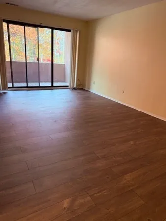 wooden floor in an empty room with a window