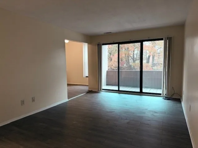 an empty room with wooden floor and sliding door