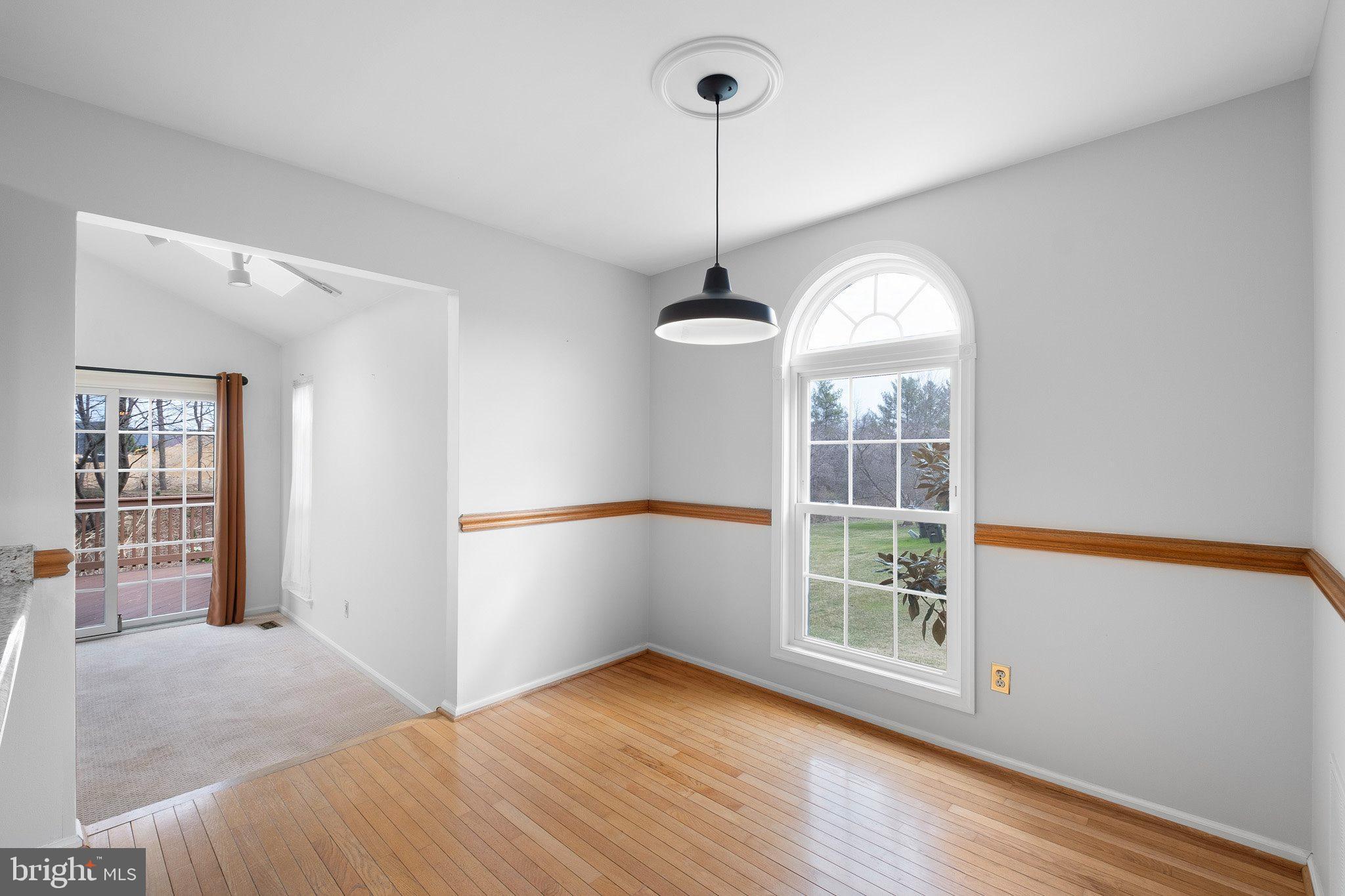 163 Cambridge Circle, Unit 78 Kennett Square, PA 19348 - Photo 11 of 30 a view of an empty room with wooden floor and a window