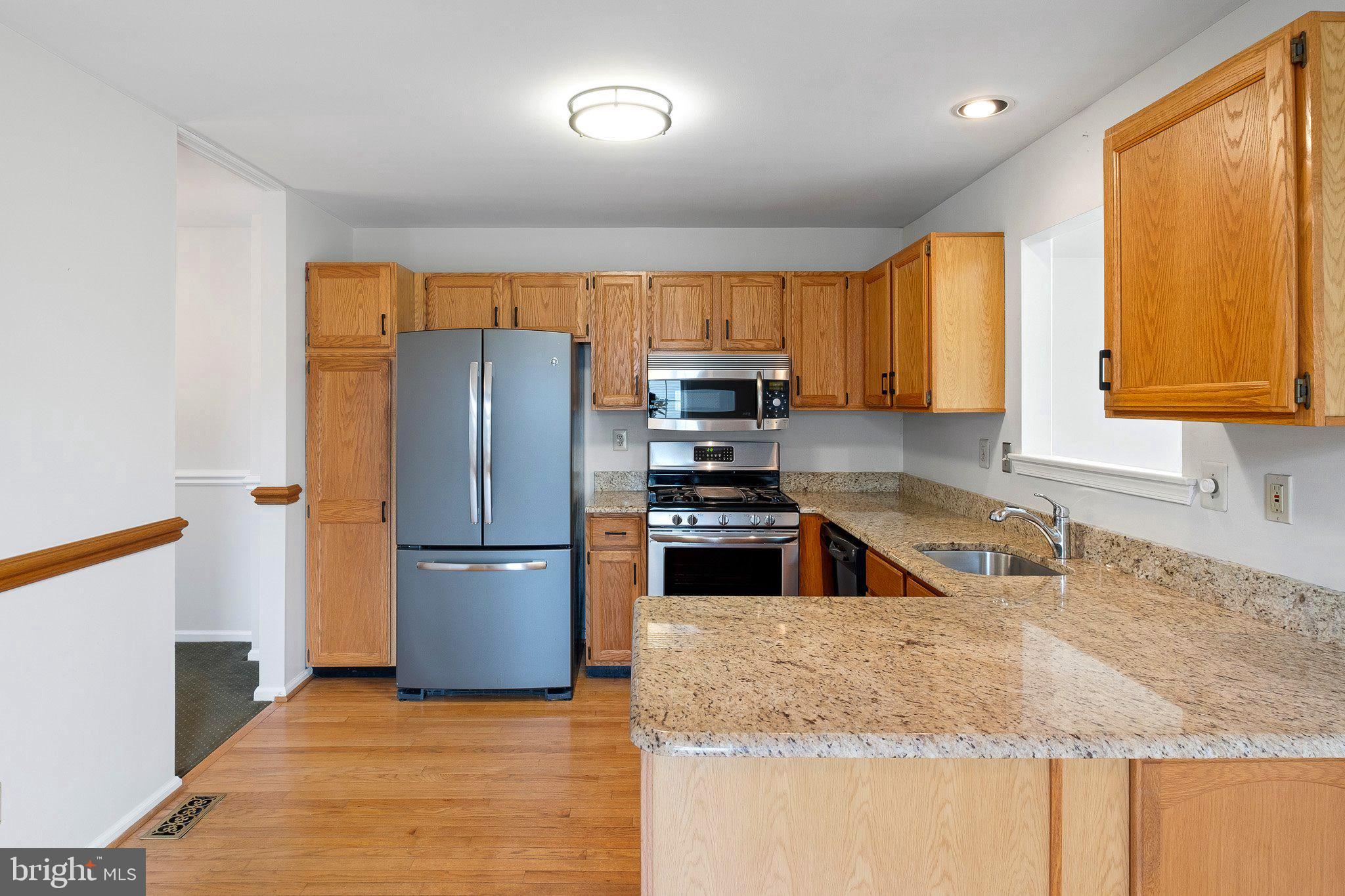 163 Cambridge Circle, Unit 78 Kennett Square, PA 19348 - Photo 8 of 30 a kitchen with granite countertop a refrigerator and a sink